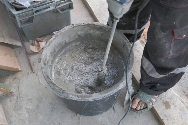 İşçi kovada çimento harcı yoğurur