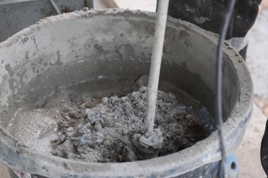 İşçi kovada çimento harcı yoğurur