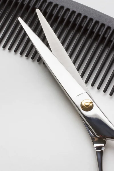 Ножницы для работы парикмахеров и расческа на белой спине — стоковое фото