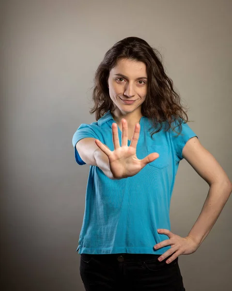 Brünette frau mit hand out — Stockfoto