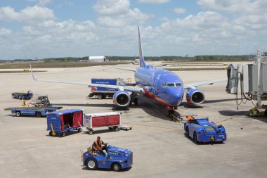 Orlando FL - ABD - 18 Mayıs 2017 - Bir Güneybatı Havayolları 737, güneşli bir gün için kalkışa hazırlanan römorkör ile kapıda hizmet alıyor.