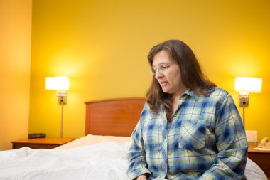 Bir kupa kahve tutan üzülmüş otel odasında yalnız kadın