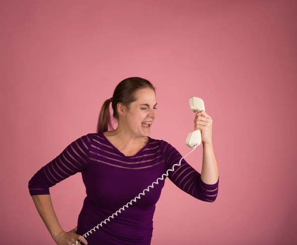 Naštvaná žena na provázkový telefon — Stock fotografie