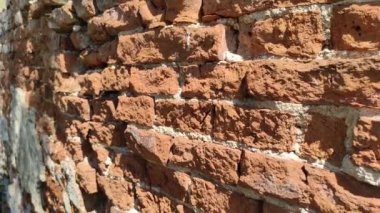 Eski kırmızı tuğla duvar yıpranmış. Güneşli bir gün. Tasarım ve sanat.