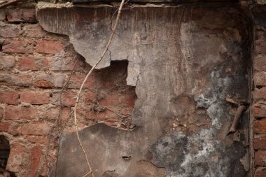 Eski püskü bir duvarın dokusu. Alçıdaki eski tuğlaların ve çatlakların geçmişi. Sarı ve kahverengi tonlar.