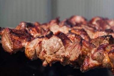 Et şişte bir şişte pişiyor. Şiş arka plan ve doku. Derili lezzetli et.
