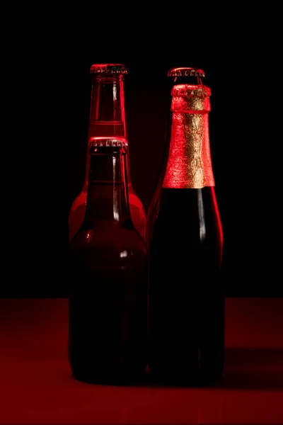 Siluetas Cuatro Botellas Cerveza Sobre Fondo Negro Iluminadas Con Luz —  Fotos de Stock
