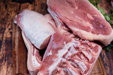 Tahta kesme tahtasında bir sürü taze domuz eti var.