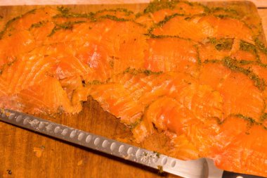 Ahşap bir tahtanın üzerinde dereotlu ve baharatlı somon füme..