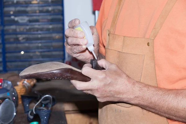 Shoemaker repairs a shoe — Stock Photo, Image