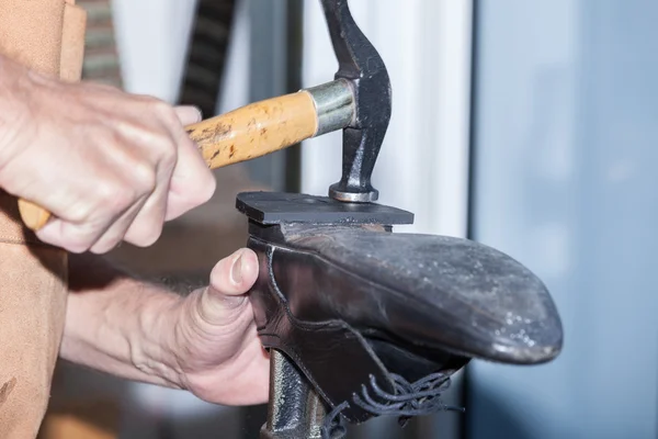 Shoemaker repairs a shoe — Stock Photo, Image