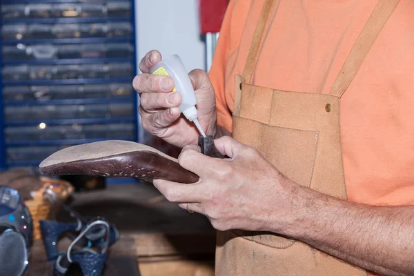 Shoemaker repairs a shoe — Stock Photo, Image