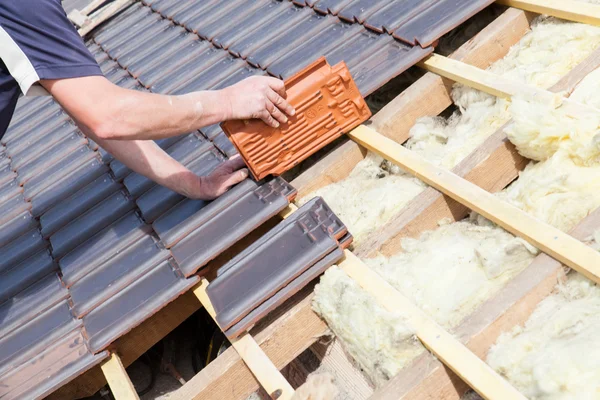 Roofer colocación de baldosas en el techo Imagen de archivo