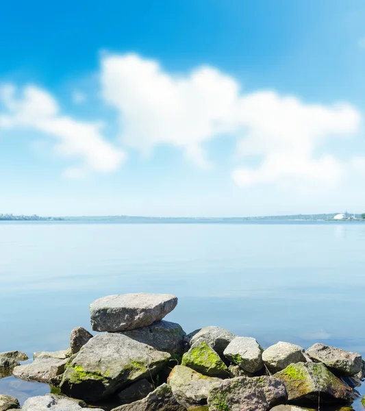 Haufen Steine am Fluss unter Wolken. Soft-Fokus. — Stockfoto