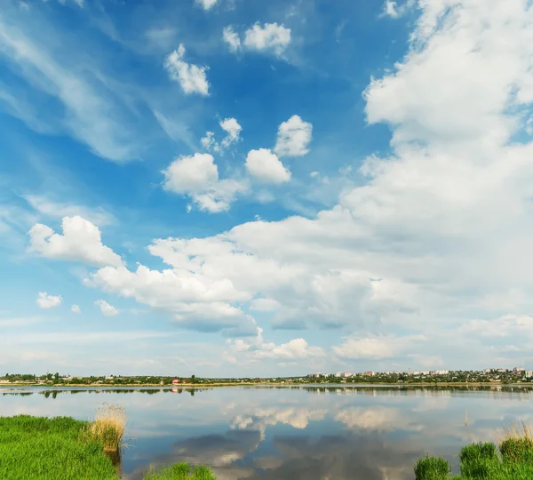 Clouds in blue sky with reflections in river — Stock Photo, Image