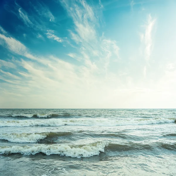 Blue sky with clouds and stormy sea in sunset — Stock Photo, Image