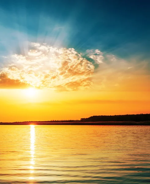 Tramonto luminoso arancia in nubi sopra il fiume — Foto Stock