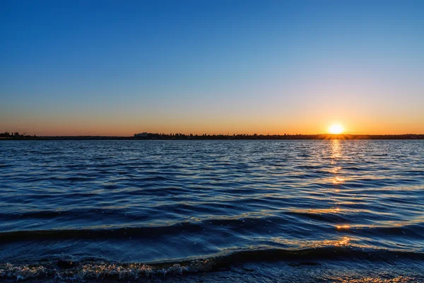Sunrise in blue sky over river — Stock Photo, Image