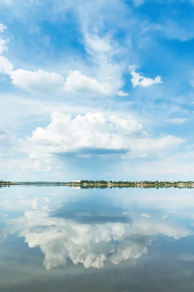 Una gran nube en el cielo azul y reflejo en el río — Foto de Stock