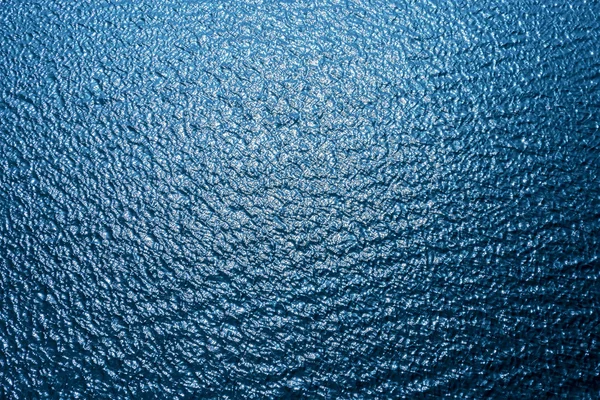 Acqua blu scuro con le onde e riflessi di sole — Foto Stock