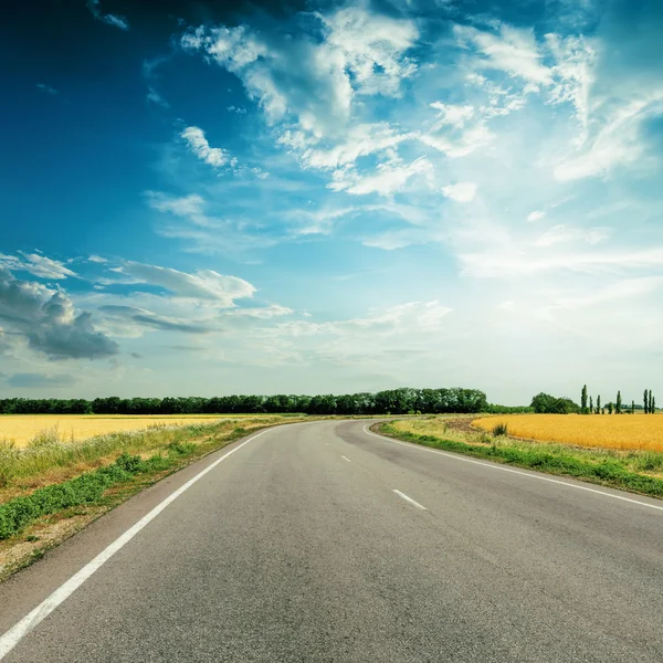 Carretera asfaltada al horizonte bajo el espectacular cielo —  Fotos de Stock