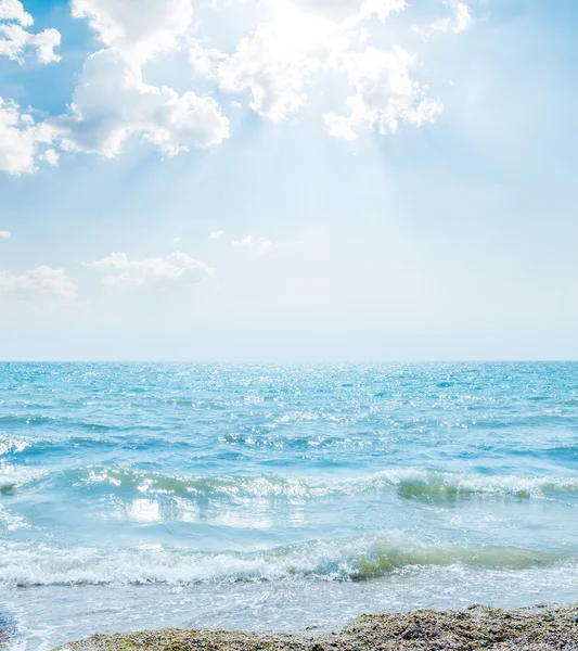 Wave on sea and clouds in blue sky with sun — Stock Photo, Image
