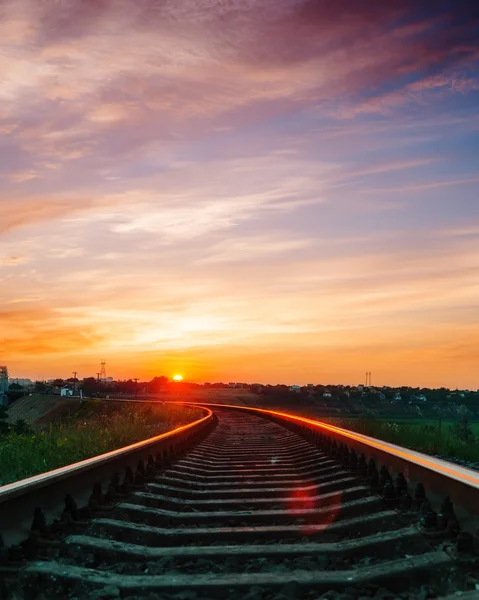 Sunset over railroad in violet sky with clouds — Stock Photo, Image
