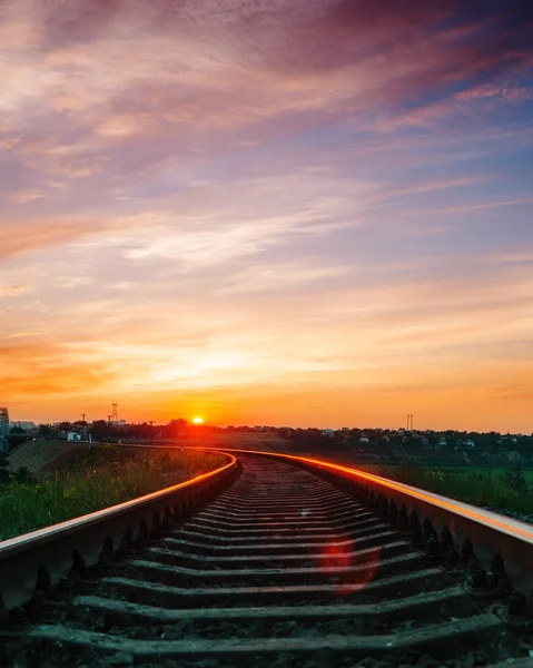 Tramonto sopra la ferrovia in cielo viola con le nubi — Foto Stock