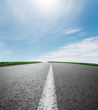 ufuk gökyüzü bulutlar ve güneş altında asfalt yol