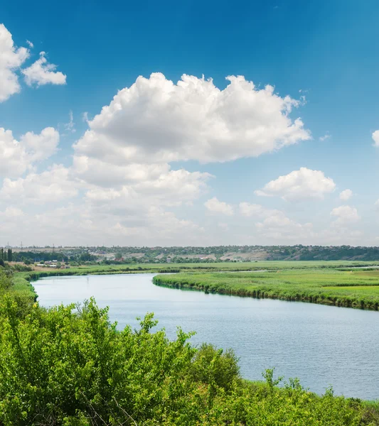 Cielo blu con nuvole bianche sul fiume in riva al fiume verde — Foto Stock