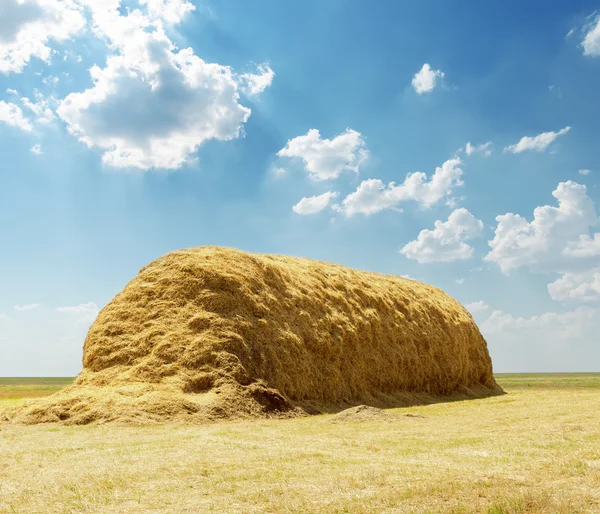 Stack av halm under blå himmel med moln — Stockfoto