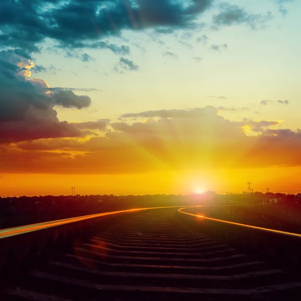 Pôr-do-sol dramático vermelho sobre a ferrovia com reflexões — Fotografia de Stock