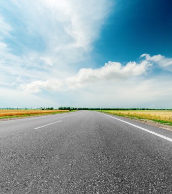 siyah asfalt yol ve dramatik gökyüzünde bulutlar