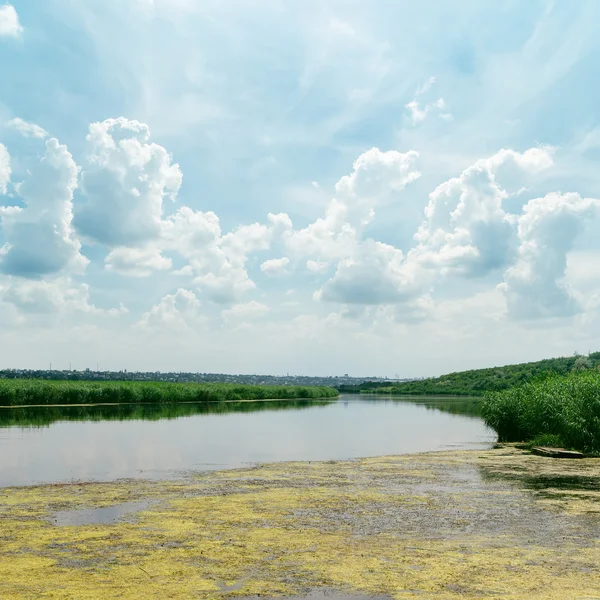 Mraky na modré obloze nad řekou — Stock fotografie