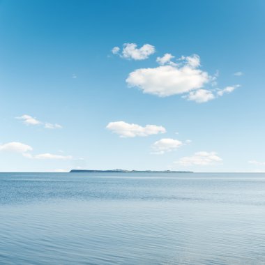 deniz üzerinde mavi gökyüzünde beyaz bulutlar