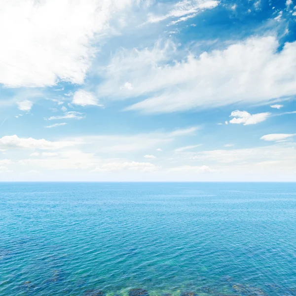 Тучи в голубом небе над морем — стоковое фото