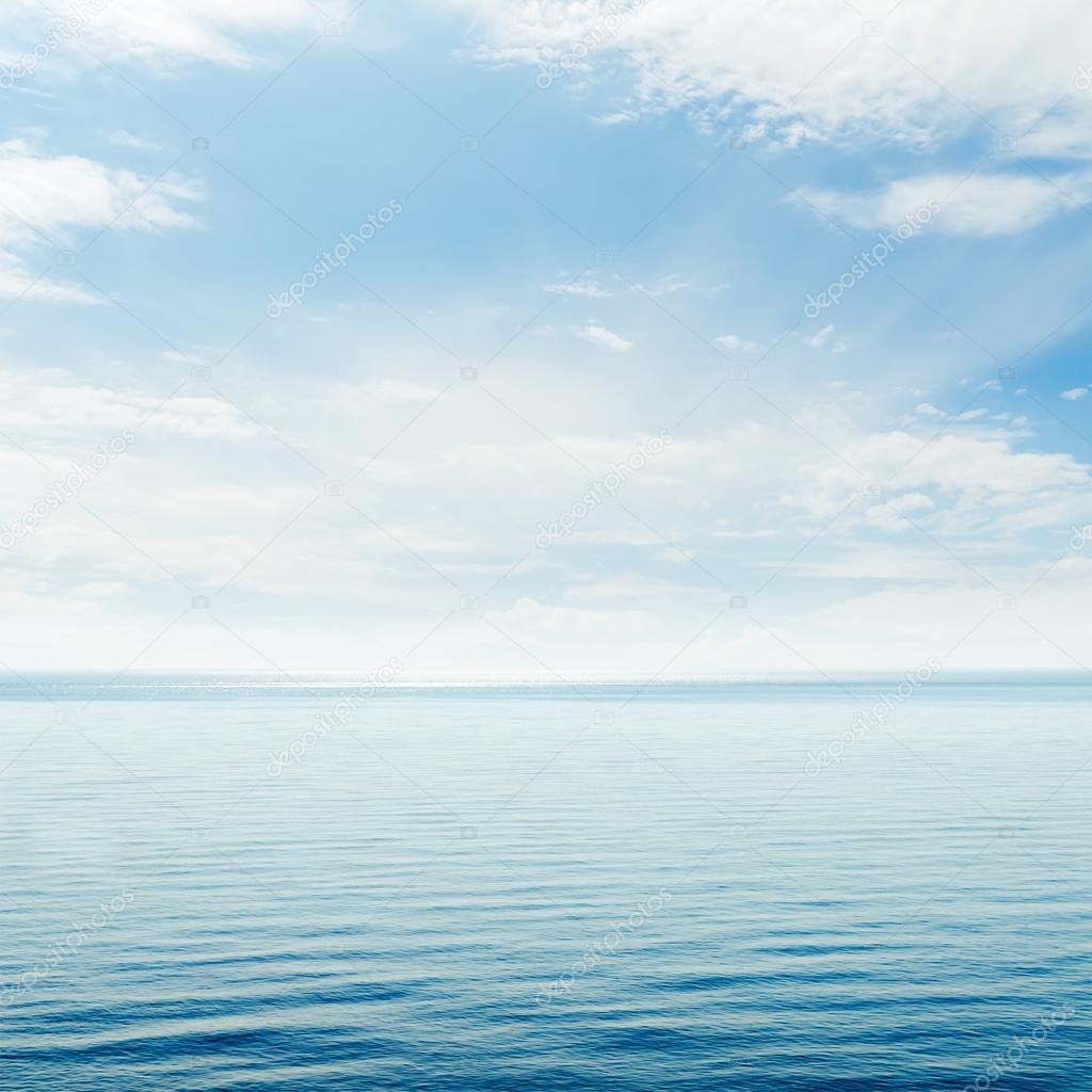 blue sea and cloudy sky over it