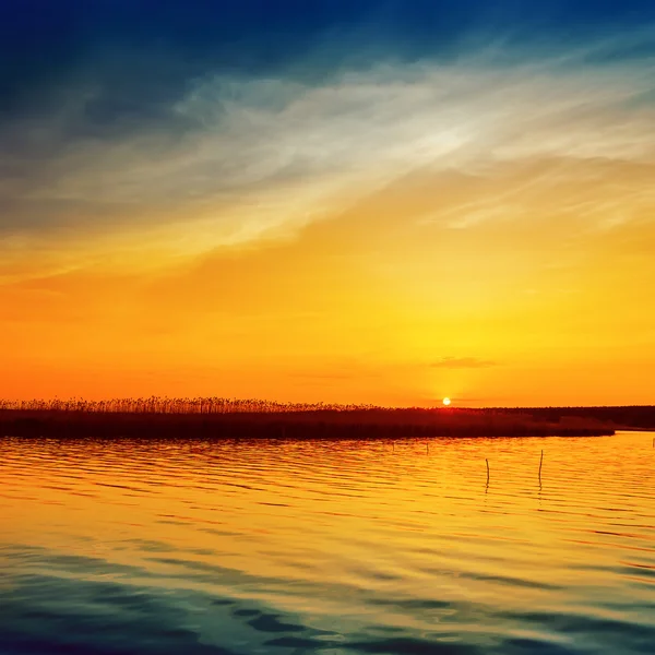 Tramonto arancione con sole basso sopra il fiume — Foto Stock