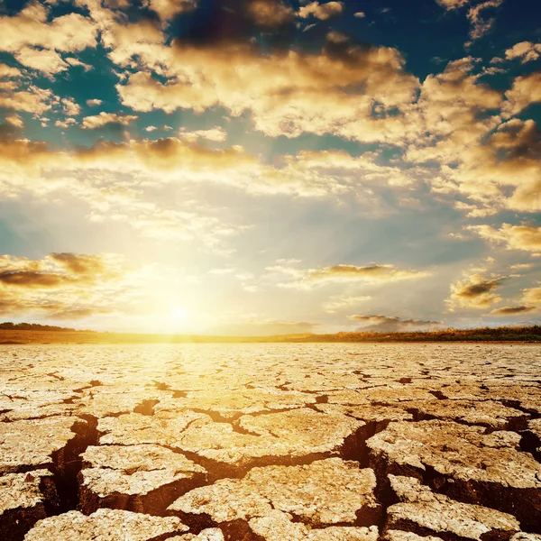 Coucher de soleil spectaculaire sur terre de la sécheresse — Photo