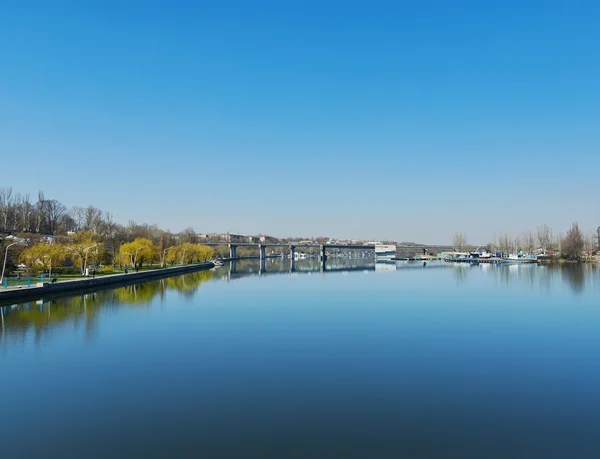 Djupblå himmel över floden med bridge — Stockfoto