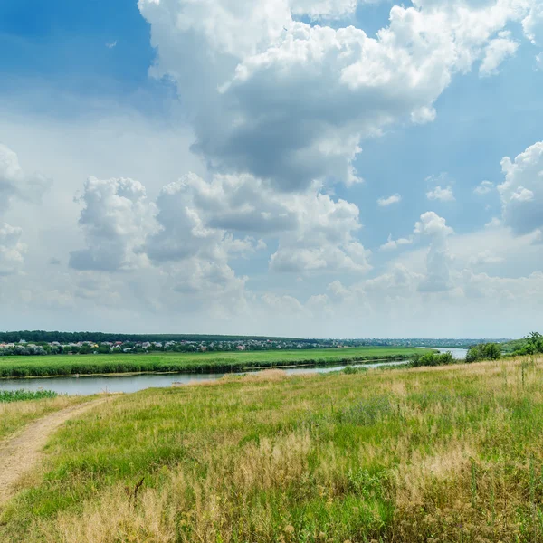 Groene landschap in de buurt van rivier onder bewolkte hemel — Stockfoto