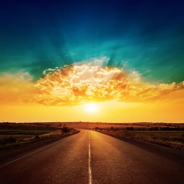 Orange Sonnenuntergang und Asphalt-Straße bis zum Horizont — Stockfoto