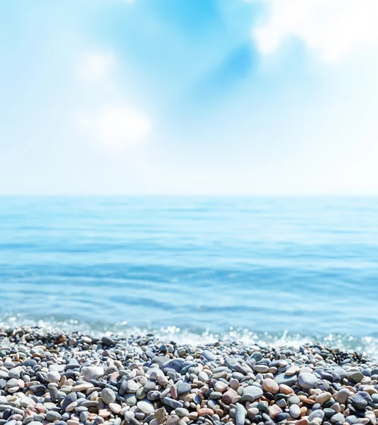 Beach with stones, sea and blue sky with clouds — Stock Photo, Image