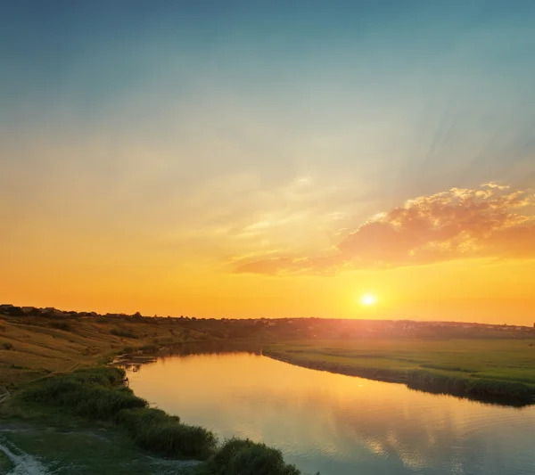 Pôr do sol laranja com nuvens sobre o rio — Fotografia de Stock