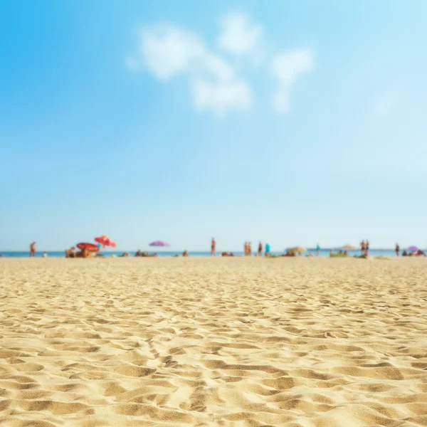 Areia na praia com mar turva e povos, céu com nuvens — Fotografia de Stock
