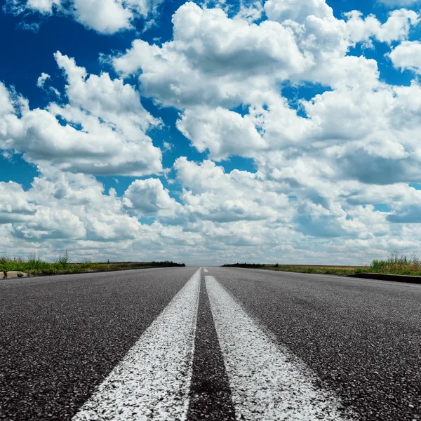 Драматичне небо над асфальтовою дорогою з двома білими лініями — стокове фото