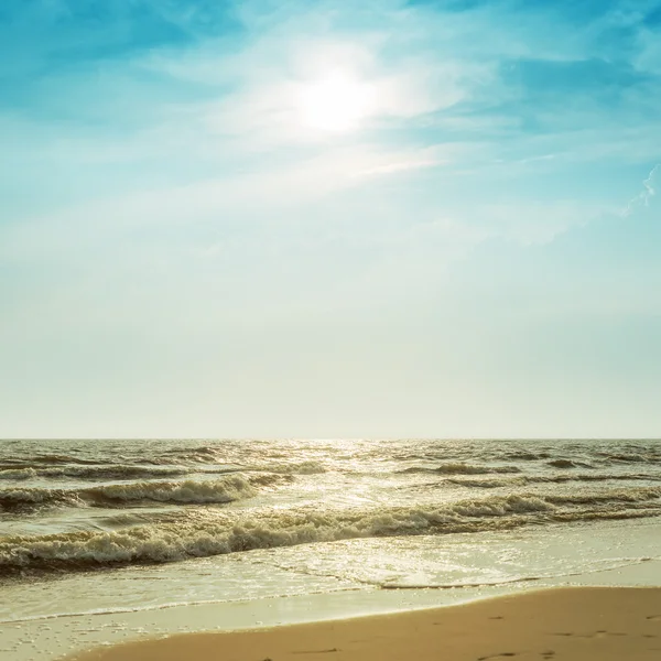 Сонце в драматичному небі над морем з хвилею — стокове фото