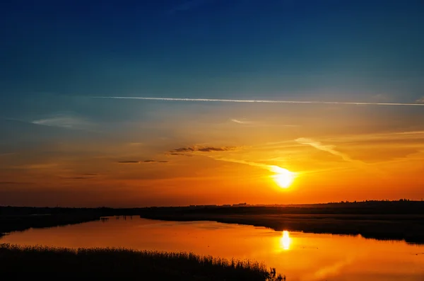 Dark orange sunset over river — Stock Photo, Image