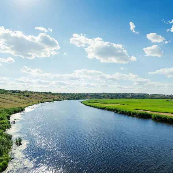 Fiume nel paesaggio verde e cielo nuvoloso sopra esso — Foto Stock