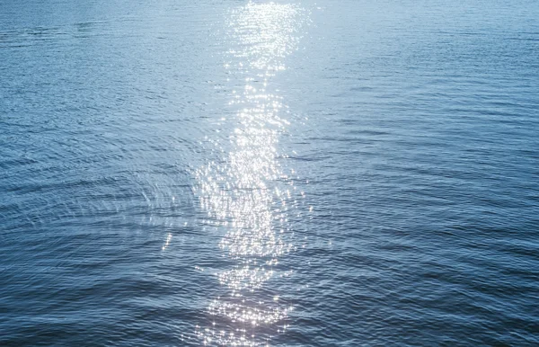 Blaue Wasser-Oberfläche mit Reflexionen der Sonne — Stockfoto